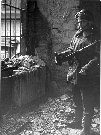 Milicjant w wypalonym gmachu KW MO w Szczecinie. (fot. Marek Czasnojć)