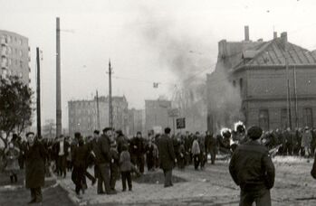 Demonstranci wokoło spalonej wyrzutni gazów łzawiących na podwoziu Gaz-69. 17.12.1970 r.